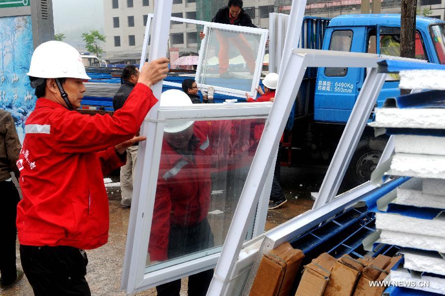 Workers unload building materials to prepare the construction of temporary housing in quake-hit Lushan County, southwest China's Sichuan Province, April 23, 2013. A 7.0-magnitude earthquake jolted Lushan County on April 20. (Xinhua/Li Ziheng)