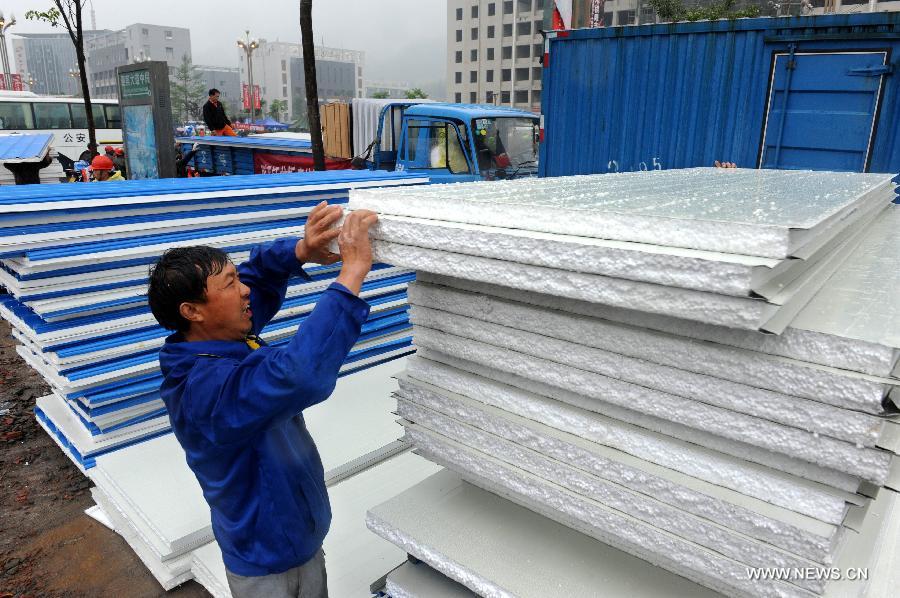 Workers unload building materials to prepare the construction of temporary housing in quake-hit Lushan County, southwest China's Sichuan Province, April 23, 2013. A 7.0-magnitude earthquake jolted Lushan County on April 20. (Xinhua/Li Ziheng)