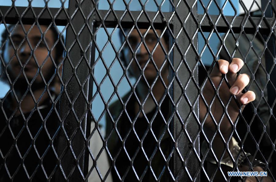 Al-Qaeda militant stand behind bars for their final hearing at a state security court in Sanaa, Yemen, on April 23, 2013. According to the official Saba News Agency, the Yemeni security court sentenced ten Yemenis to jail terms ranging from four to 6 years after convicting them of belonging to al-Qaeda in the Arabian Peninsula and forming armed terror gangs to carry out attacks against Yemeni and foreign interests. (Xinhua/Mohammed Mohammed)