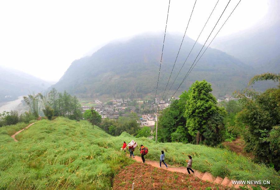 Villagers go downhill to transfer household items found in their houses to the temporary settlement in quake-hit Yuxi Village of Lushan County, southwest China's Sichuan Province, April 22, 2013. A 7.0-magnitude jolted Lushan County on April 20. (Xinhua/Xiao Yijiu)