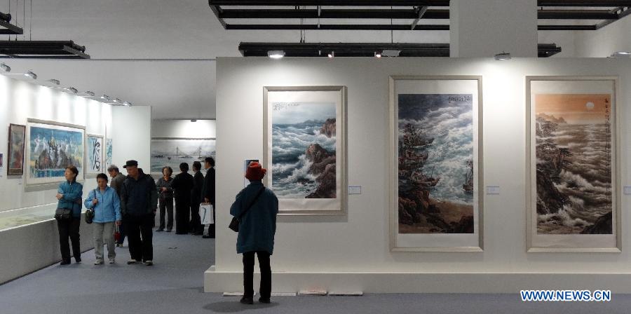 Visitors watch paintings at an art exhibition themed on Chinese ocean in Beijing, capital of China, April 24, 2013. Over 130 pieces of artworks are on display. (Xinhua/Li Xin)