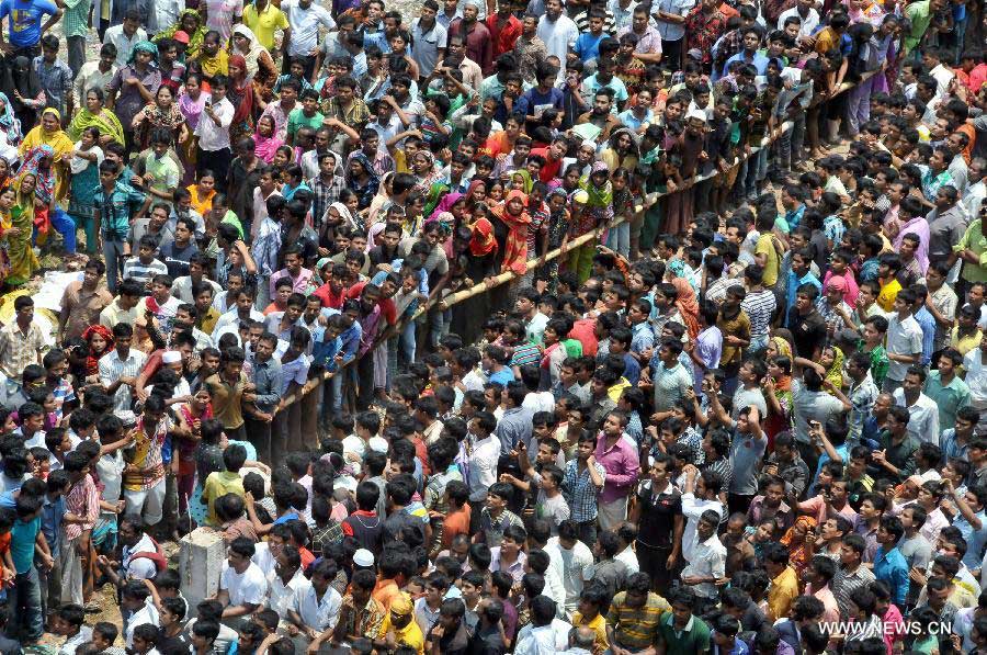 People gather in front of a collapsed building in Savar, Bangladesh, April 24, 2013. At least 70 people were killed and over six hundred injured after an eight-storey building in Savar on the outskirts of the Bangladeshi capital Dhaka collapsed on Wednesday morning. (Xinhua/Shariful Islam) 