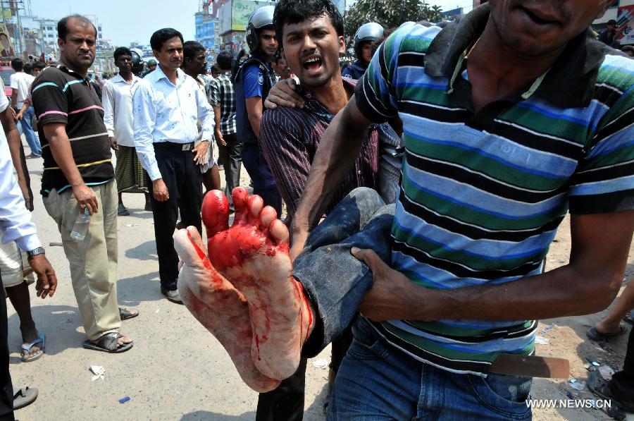 Local people carry an injured garment worker after a building collapsed in Savar, Bangladesh, April 24, 2013. At least 70 people were killed and over six hundred injured after an eight-storey building in Savar on the outskirts of the Bangladeshi capital Dhaka collapsed on Wednesday morning. (Xinhua/Shariful Islam) 