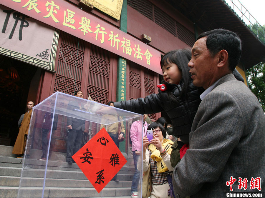 A child puts money into the donation box.(Photo:Li Chenyun/CNS)