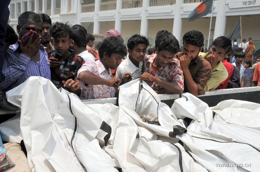 Relatives identify the bodies near the site of the collapsed Rana Plaza building in Dhaka, Bangladesh, April 25, 2013. Rescue workers continued their struggle Thursday to reach many more who are feared trapped in the rubble one day after a building collapse in Savar on the outskirts of Bangladesh's capital Dhaka, with the death toll rising to 195. (Xinhua/Shariful Islam) 