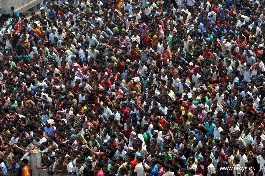 People gather in front of the collapsed building while the rescuers' operation is processing in the collapsed Rana Plaza building in Dhaka, Bangladesh, April 25, 2013. Rescue workers continued their struggle Thursday to reach many more who are feared trapped in the rubble one day after a building collapse in Savar on the outskirts of Bangladesh's capital Dhaka, with the death toll rising to 195. (Xinhua/Shariful Islam)