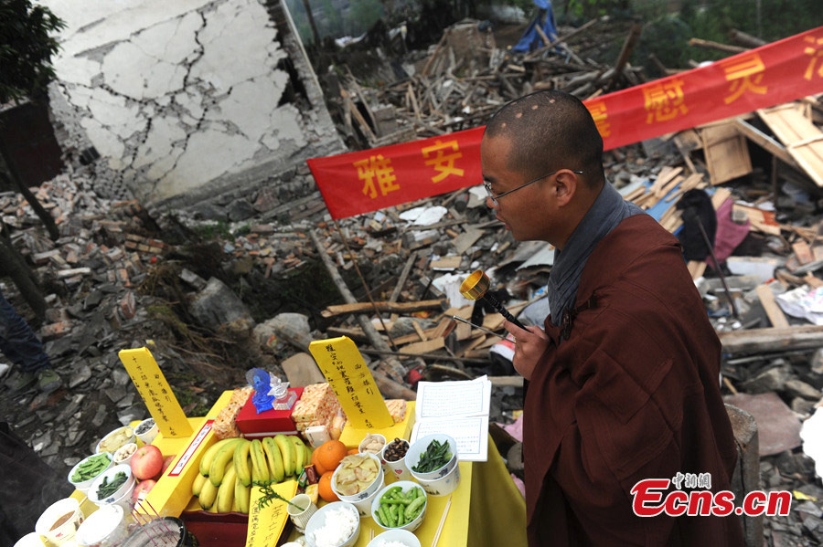 A monk of the Shaolin Temple prays for the victims of the 7.0-magnitude earthquake in Lushan County, Ya'an, Southwest China's Sichuan Province, April 26, 2013. On the early morning of April 23, nine monks and staff member from the Songshan Shaolin Temple came to the disaster area of Lushan. They bring large quantities of traditional Chinese medicine products made by Shaolin pharmacy and two equipment vehicles for Western medicine treatment. （Photo: CNS/Zhang Lang）