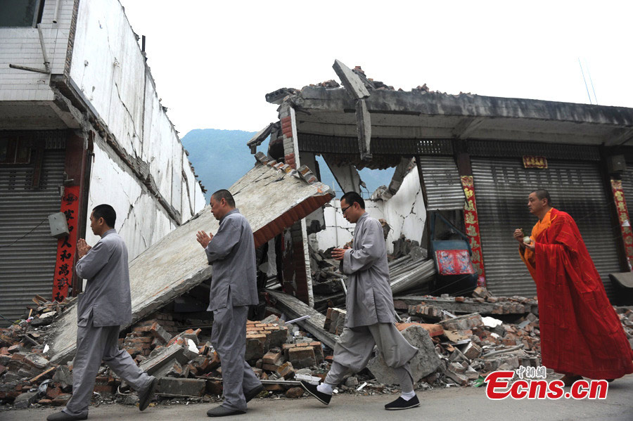 Monks of the Shaolin Temple pray for the victims of the 7.0-magnitude earthquake in Lushan County, Ya'an, Southwest China's Sichuan Province, April 26, 2013. On the early morning of April 23, nine monks and staff member from the Songshan Shaolin Temple came to the disaster area of Lushan. They bring large quantities of traditional Chinese medicine products made by Shaolin pharmacy and two equipment vehicles for Western medicine treatment. （Photo: CNS/Zhang Lang）