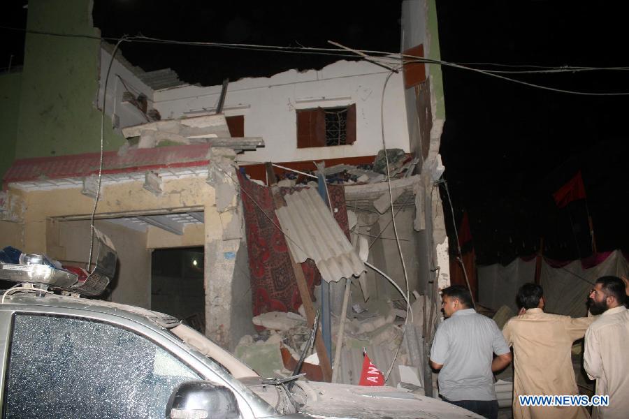 People gather at the blast site in southern Pakistani port city of Karachi on April 26, 2013. At least 11 people including a child were killed and 40 others injured on Friday night in a bomb blast that targeted a political meeting in Pakistan's southern port city of Karachi, local media and police said. (Xinhua/Masroor) 