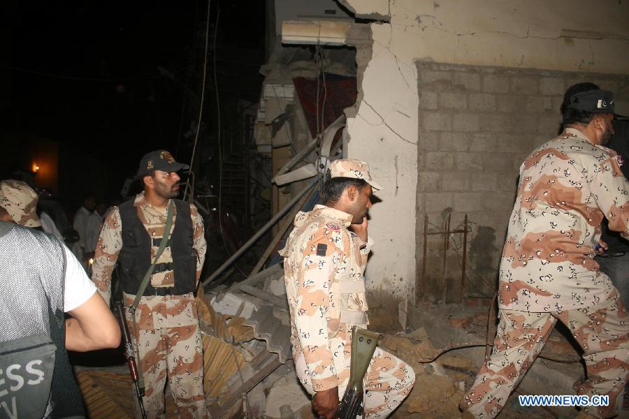 People gather at the blast site in southern Pakistani port city of Karachi on April 26, 2013. At least 11 people including a child were killed and 40 others injured on Friday night in a bomb blast that targeted a political meeting in Pakistan's southern port city of Karachi, local media and police said. (Xinhua/Masroor)