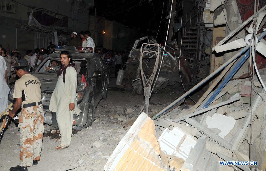 People gather at the blast site in southern Pakistani port city of Karachi on April 26, 2013. At least 11 people including a child were killed and 40 others injured on Friday night in a bomb blast that targeted a political meeting in Pakistan's southern port city of Karachi, local media and police said. (Xinhua/Masroor) 