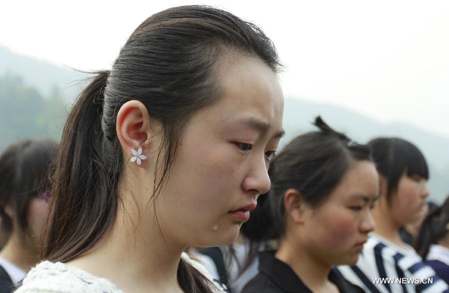 A student cries as mourning for those who died in a 7.0-magnitude quake a week ago, at the playground of Lushan Middle School in Lushan County, Ya'an City, southwest China's Sichuan Province, April 27, 2013. Public mourning was held on Saturday morning in Sichuan Province for those who died in the earthquake on April 20. The quake has claimed nearly 200 lives. (Xinhua/Zhou Qiang)