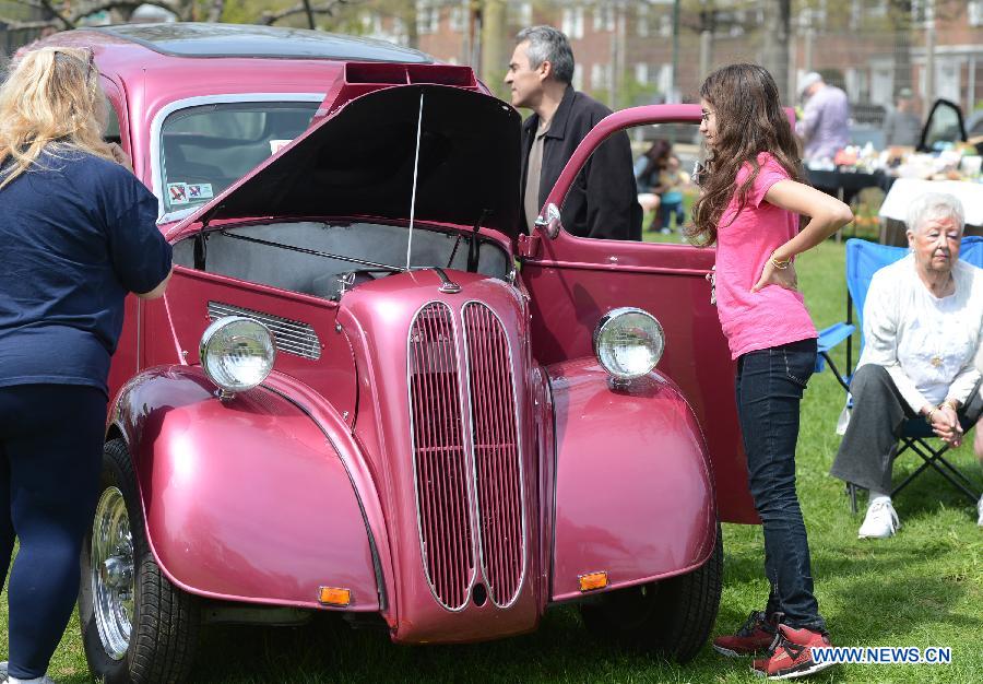 People visit a vintage car during an antique auto show in New York, the United States, on April 28, 2013. (Xinhua/Wang Lei)