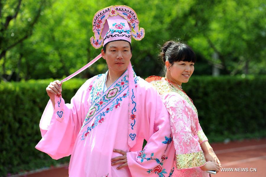 Two teachers dressed as an ancient Chinese couple pose for a photo during a costume parade in Tianyuan High School in Shanghai, east China, April 28, 2013. Teachers and students of the school dressed themselves as various real and fictional figures for a cross-culture costume parade here on Sunday. (Xinhua/Lai Xinlin) 