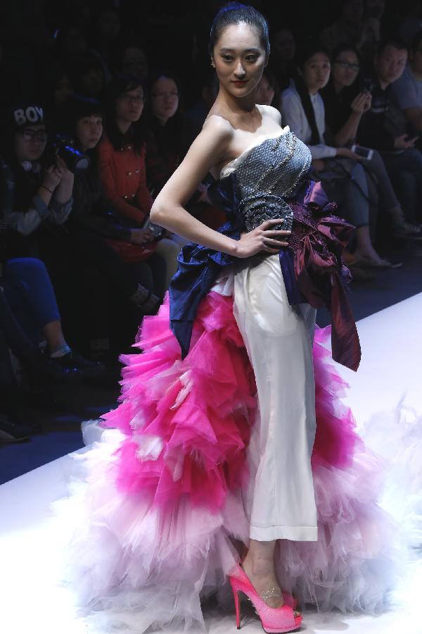 A model presents a creation designed by students from a "master training camp" during the China Graduate Fashion Week in Beijing, capital of China, April 28, 2013. (Xinhua/Li Mingfang)