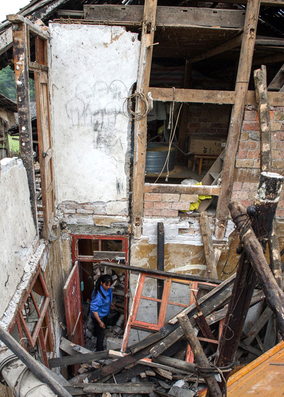 A villager inspects the damage condition of her house on April 21 after a 7.0-magnitude quake hit Lushan County, Sichuan province and claims 196 lives. (Xinhua/Chen Cheng)