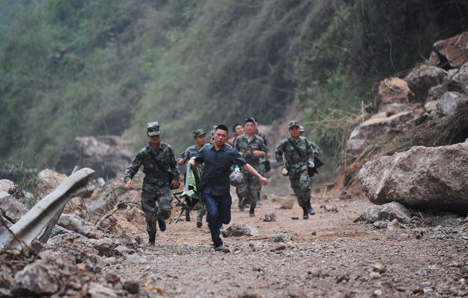 Rescuers race against time on April 21 to pass an area covered with fallen rocks in the mountainous Lushan County after a powerful earthquake one day ago. (Xinhua/Jiang Jinghong)