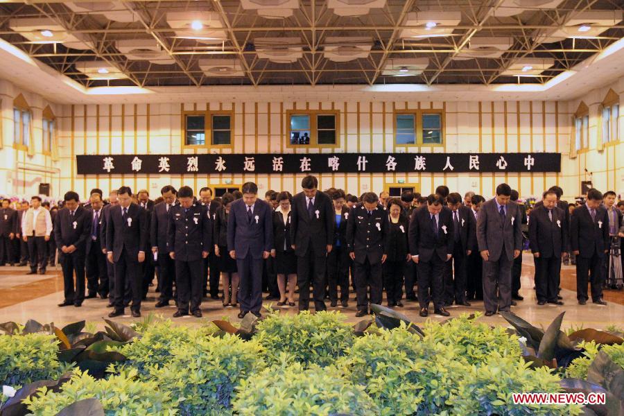 People stand in silent tribute to 15 community workers and police officers who died during a terrorist clash on April 23 in Bachu County, Kashgar Prefecture, northwest China's Xinjiang Uygur Autonomous Region, April 29, 2013. During a commendation meeting held on Monday, the regional Communist Party of China (CPC) committee and government posthumously awarded the 15 individuals each as a "regional anti-terrorist hero," seven of whom were also posthumously awarded as a "regional outstanding CPC member". (Xinhua/Zhang Huawei)