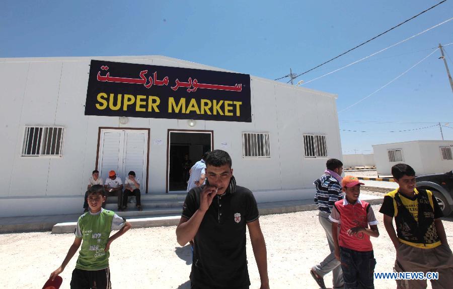 Syrian refugees exit the supermarket at the Mrajeeb Al Fhood refugee camp, 20 km (12.4 miles) east of the city of Zarqa, April 29, 2013. The Mrajeeb Al Fhood camp, with funding from the United Arab Emirates, has received about 2500 Syrian refugees so far, according to the Red Crescent Society of the United Arab Emirates. (Xinhua/Mohammad Abu Ghosh)