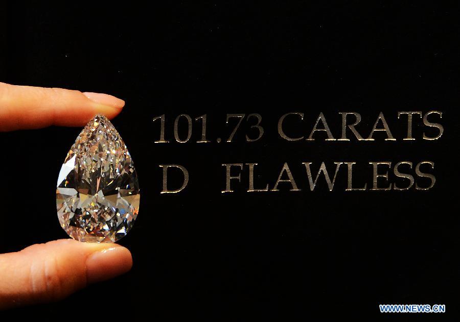 A worker shows the 101.73-carat diamond to the media at the Christie in Geneva, Switzerland, April 30, 2013. Christie will hold spring sale of Jewels auction in Geneva on May 15, 2013. Led by a truly sensational pear-shaped, D colour, flawless diamond of 101.73 carats, the sale will reach to an estimated combined total of 65 million dollars. This Type IIA Flawless gem was found at the Jwaneng mine in Botswana and took 21 months to polish. This gemstone is estimated to be sold at a price between 20 to 30 million dollars and the successful buyer will have the privilege of endowing the diamond a name. (Xinhua/Wang Siwei)