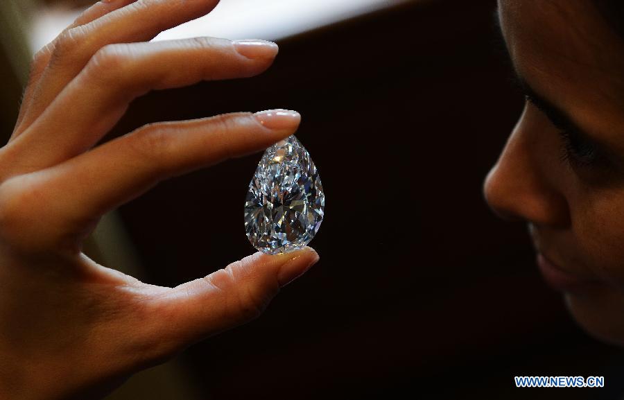 A worker shows the 101.73-carat diamond to the media at the Christie in Geneva, Switzerland, April 30, 2013. Christie will hold spring sale of Jewels auction in Geneva on May 15, 2013. Led by a truly sensational pear-shaped, D colour, flawless diamond of 101.73 carats, the sale will reach to an estimated combined total of 65 million dollars. This Type IIA Flawless gem was found at the Jwaneng mine in Botswana and took 21 months to polish. This gemstone is estimated to be sold at a price between 20 to 30 million dollars and the successful buyer will have the privilege of endowing the diamond a name. (Xinhua/Wang Siwei)