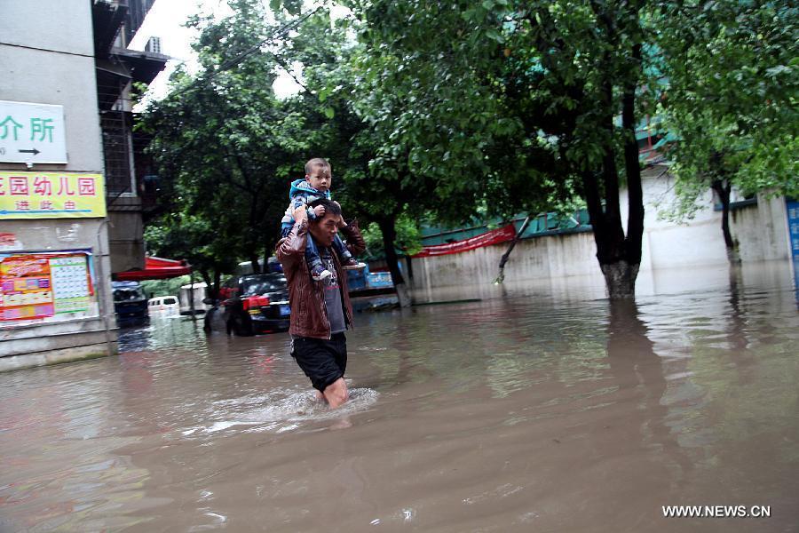 People wade through a flooded road in Guilin of southwest China's Guangxi Zhuang Autonomous Region, April 30, 2013. Heavy rainfall hit many places in Guangxi on April 29 and 30. (Xinhua/Fu Xingxue)