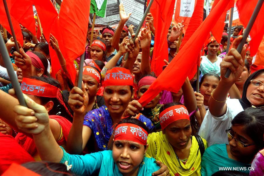 Bangladeshi garments workers stage a procession to mark International Labor Day in Dhaka, Bangladesh, May 1, 2013. The historic Labor Day was observed in the country as elsewhere across the world Wednesday with a pledge to safeguard rights of workers.(Xinhua/Shariful Islam)