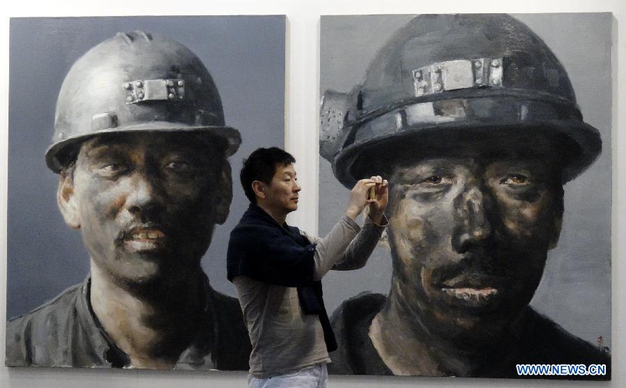 A visitor takes photos at the Art Beijing 2013 in Beijing, capital of China, May 1, 2013. Opened Wednesday at Agricultural Exhibition Center in Beijing, the annual art fair attracted some 150 participating art organizations. (Xinhua/Li Xin)