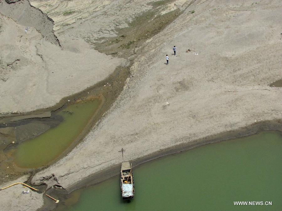 Photo taken on May 1, 2013 shows the naked riverbed at the Yunxian segment of the Hanjiang River in Yunxian County, central Province. The water level of the Hanjiang River in Yunxian County keeps declining since this spring due to the low rainfall, affecting the river's navigation. The water level here by 12 p.m. on May 1 stood at 137.49 meters, 19.65 meters less than the highest level of last year. (Xinhua/Cao Zhonghong)