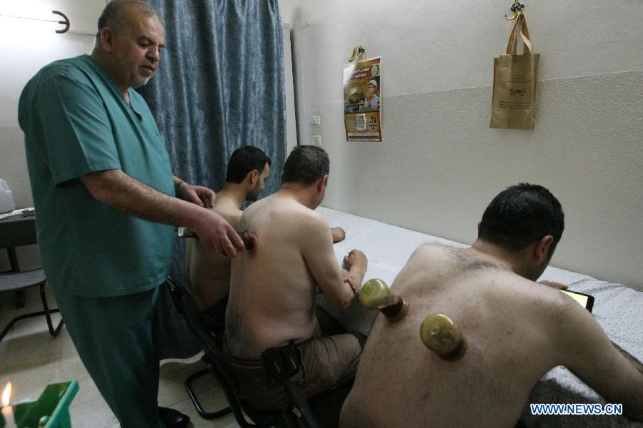 Patients receive cupping treatments in the West Bank city of Hebron, on May 2, 2013. In the West Bank city of Hebron Cupping therapy is used to treat many medical conditions like skin problems, blood disorders, fertility disorders and stroke. The process involves pricking the skin with needles before immediately applying a cup on top to draw congealed blood. (Xinhua/Mamoun Wazwaz)