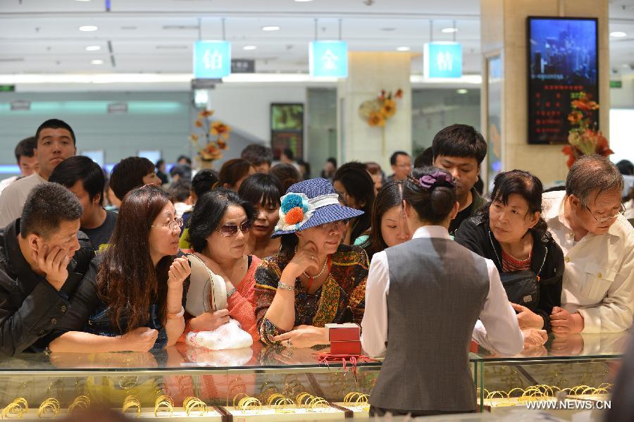 Customers select gold accessories in Caibai, one of best-known gold retailers in Beijing, China, May 2, 2013. Sales of gold reached 200 million RMB (32.44 million U.S. dollars), up 30 percent year on year during the three-day May Day holiday at Caibai due to recent abrupt price drop for the precious metal. (Xinhua/Li Xin) 