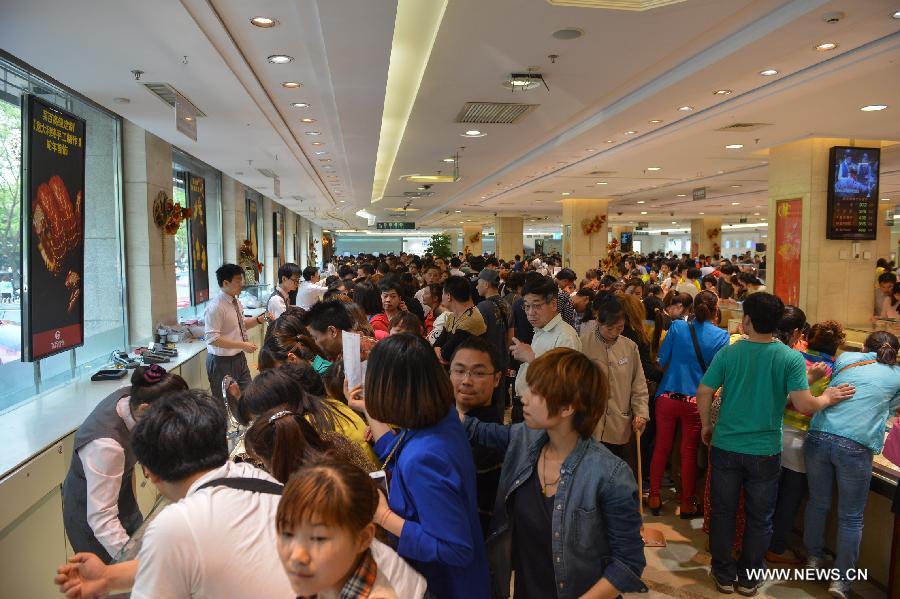 Customers select gold accessories in Caibai, one of best-known gold retailers in Beijing, China, May 2, 2013. Sales of gold reached 200 million RMB (32.44 million U.S. dollars), up 30 percent year on year during the three-day May Day holiday at Caibai due to recent abrupt price drop for the precious metal. (Xinhua/Li Xin) 