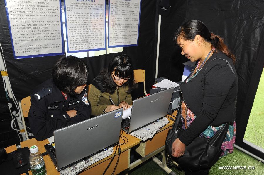 A displaced woman registers with the police at a school served as an evacuation settlement for displaced people in the quake-hit Baoxing County, southwest China's Sichuan Province, May 2, 2013. Some 4,000 displaced people live in the settlement, the largest in the county, after a strong earthquake hit Baoxing last month. At present, basic living needs of those people could be guaranteed in terms of food, drink, healthcare service and power supply. (Xinhua/Lu Peng)