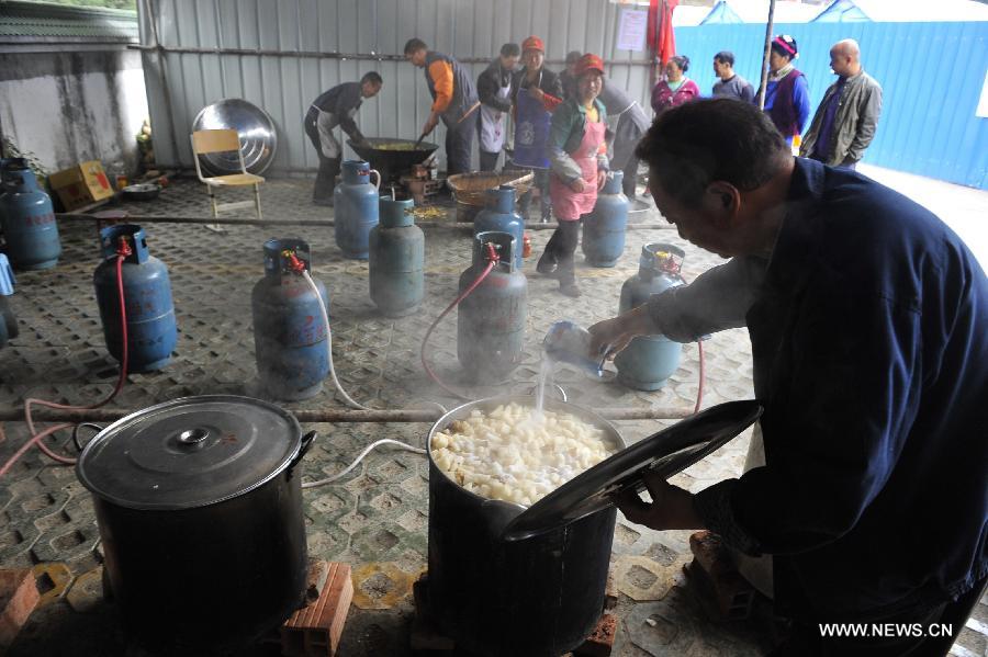 Volunteers prepare for lunch at a school served as an evacuation settlement for displaced people in the quake-hit Baoxing County, southwest China's Sichuan Province, May 2, 2013. Some 4,000 displaced people live in the settlement, the largest in the county, after a strong earthquake hit Baoxing last month. At present, basic living needs of those people could be guaranteed in terms of food, drink, healthcare service and power supply. (Xinhua/Lu Peng)