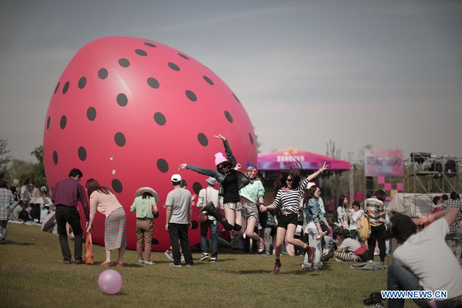 Girls jump into air for photos during the 5th Strawberry Music Festival at the Tongzhou Canal Park in Beijing, capital of China, May 1, 2013. The three-day festival, which attracted more than 160 performing teams from home and abroad, concluded on May 1. (Xinhua/Yao Jianfeng)