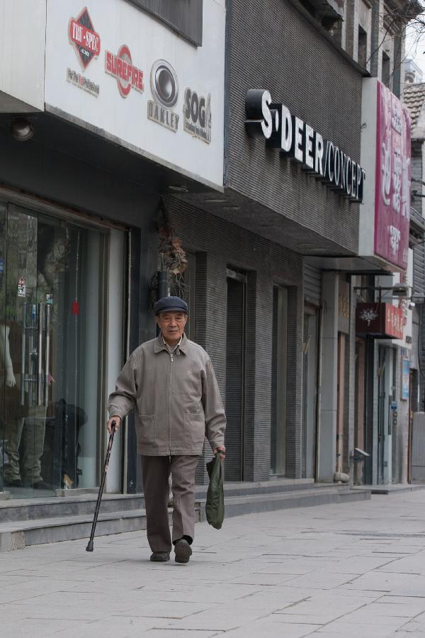 Zhang Guangyi walks home after work in Beijing, capital of China, April 26, 2013. (Xinhua/Xu Zijian) 