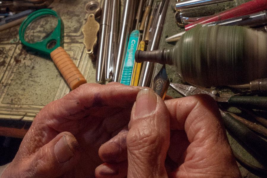 Zhang Guangyi polishes a pen-tip at his shop in Beijing, capital of China, April 24, 2013. (Xinhua/Xu Zijian)