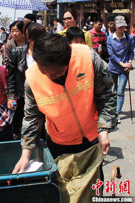 Many tourists take rest on the mountain at night and leave garbage. When visitors leave, Zhang and his colleagues have to clean up the garbage left behind without delay. (Photo by Li Xianglei/ Chinanews.com)