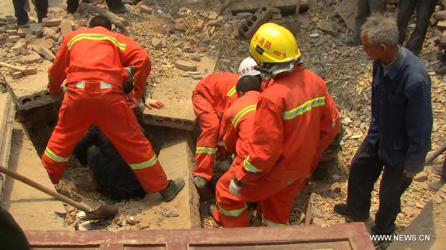 Rescuers try to save a survivor at the site where a two-story building collapsed in Hedao village, Fengzhuang township in Yanjin County, central China's Henan Province, May 3, 2013. The building collapsed on Friday morning, leaving at least seven workers dead. Thirty-seven people, most of them women, were lifting the building's foundations when it toppled. Twenty-one people have been rescued from the collapsed building. Rescue efforts are continuing. (Xinhua/Li Zhi)