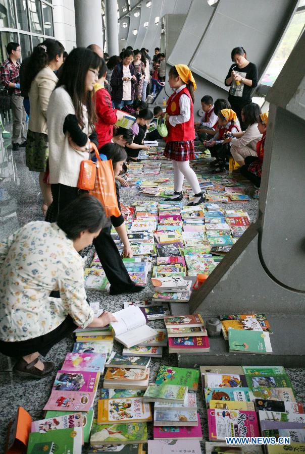 Parents select books at the secondhand book fair in Nanjing, capital of east China's Jiangsu Province, May 5, 2013. During the fair, pupils and middle school students could sell or exchange their idle books, stationery and toys as well, by which they were expected by the organizer to learn a frugal lifestyle. (Xinhua/Wang Xin)