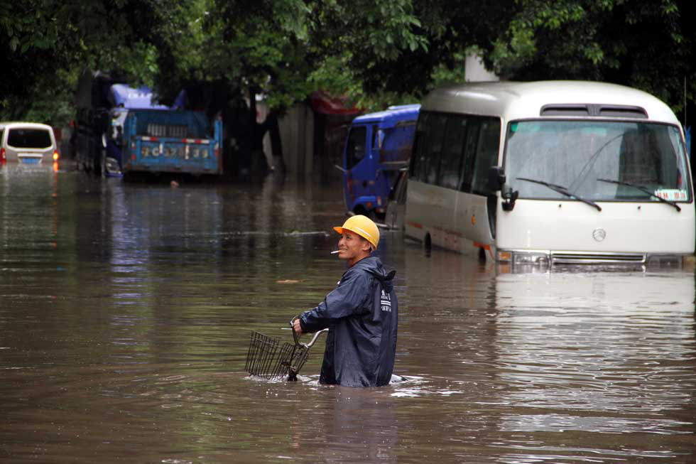 A rider pushes his bike in flood water in Guilin, south China's Guangxi Zhuang autonomous region, April 30, 2013. Heavy rainfall hit Guangxi on April 29, damaging houses and causing floods and road cave-ins as well. (Xinhua/Ren Jiaxiang)