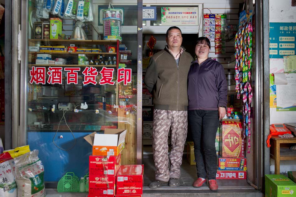 Xu Changzheng (L) and his wife stand in front of their convenient shop. The two became laid off workers during the reform of a state-owned textile enterprise in Anhui province 10 years ago. They set up the little convenient shop to make a living in 2003. (Xinhua Photo/ Guo Chen)