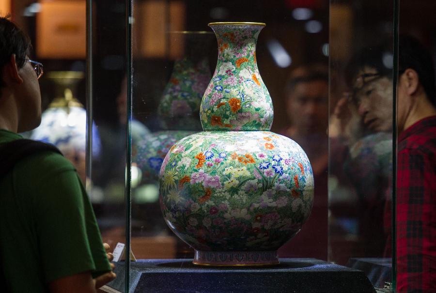 People look at exhibits during the preview of China Guardian 2013 Spring Auctions in Beijing, capital of China, May 7, 2013. The three-day preview that opened on Tuesday displayed some 3,900 treasures to be auctioned on Friday. (Xinhua/Luo Xiaoguang) 