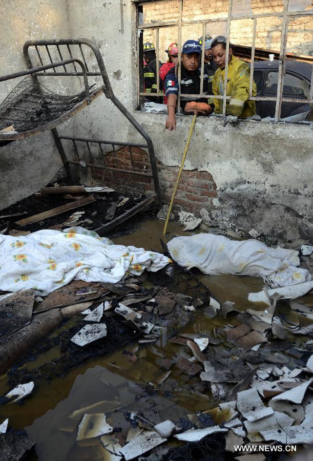 Firemen and police inspect the site of an explosion on the Mexico-Pachuca highway in Ecatepec, Mexico, on May 7, 2013. At least 20 people were killed and 34 injured when a gas tanker exploded early Tuesday in a Mexico City suburb, security officials said. (Xinhua/Susana Martinez) 