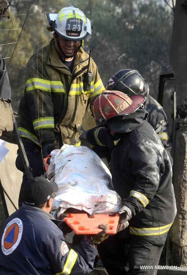 Firemen carry the body of a victim out of the site of an explosion on the Mexico-Pachuca highway in Ecatepec, Mexico, on May 7, 2013. At least 20 people were killed and 34 injured when a gas tanker exploded early Tuesday in a Mexico City suburb, security officials said. (Xinhua/Susana Martinez) 