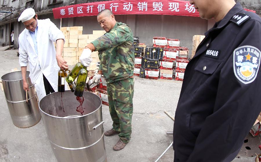 Police destroy counterfeit red wines in Shanghai, east China, May 7, 2013. Local police smashed over 3,000 bottles of counterfeit red wines worth of more than 40 million Yuan (approximately 6.5 million US dollars). (Xinhua/Fan Jun) 