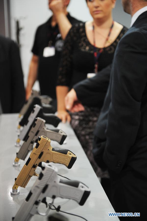 People visit a gun company booth from Turkey in Istanbul, Turkey, May 7, 2013. The 11th International Defence Industry Fair was opened on Tuesday, with 781 companies from 82 countries and regions attending the four-day fair. (Xinhua/Lu Zhe)