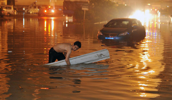 Residents wade through the rain-drenched street in Changsha, capital of Central China's Hunan province on May 7. [Photo /Xinhua]