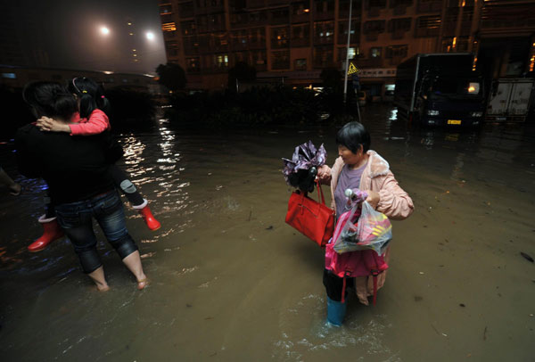 Residents wade through the rain-drenched street in Changsha, capital of Central China's Hunan province on May 7. [Photo /Xinhua]