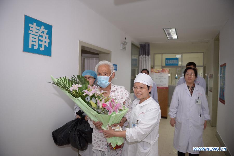 An 80-year-old H7N9 avian influenza patient, who has made full recovery, is helped to walk out of the ward in hospital in Nanchang, capital of east China's Jiangxi Province, May 8, 2013. The old man, surnamed Xiong, was discharged from the hospital on Wednesday. (Xinhua/Zhou Mi)